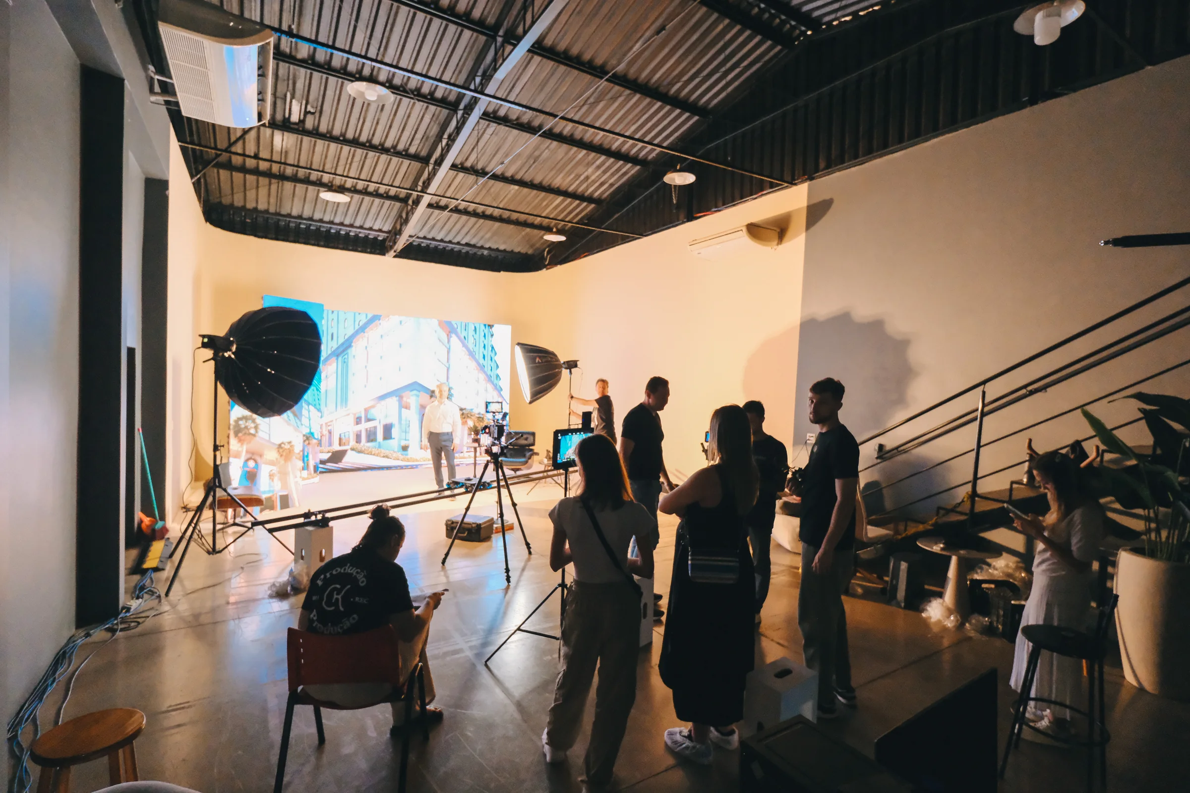 Vista ampla do estúdio com equipe, iluminação e cenário montados para uma produção.